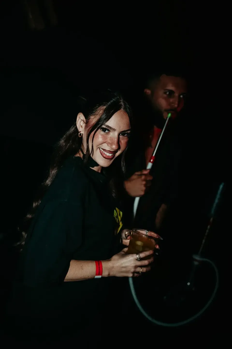 Chica sonriendo con una copa en la mano en la pista