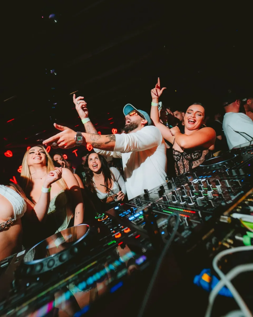 Vista desde la cabina: el DJ y el público con los brazos en alto
